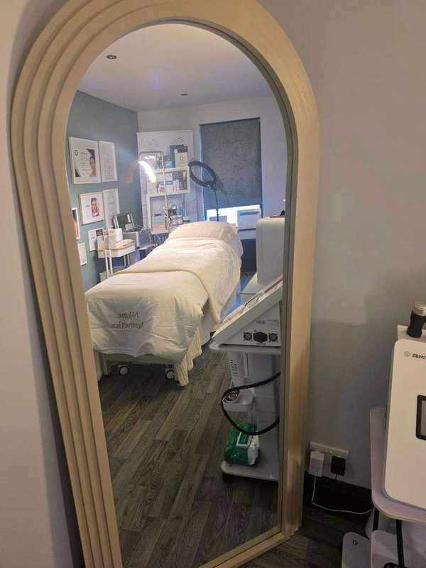 The treatment room reflected in an arched mirror
